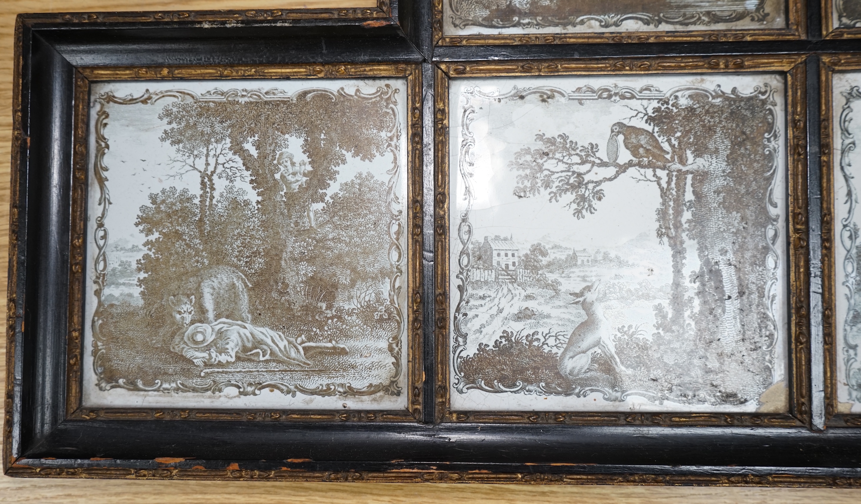 A framed set of six 18th century Liverpool delftware black and white printed tiles, Aesop’s Fables by Sadler, 57cm wide. Condition - fair